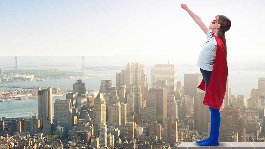 Boy in superman costume in front of cityscape