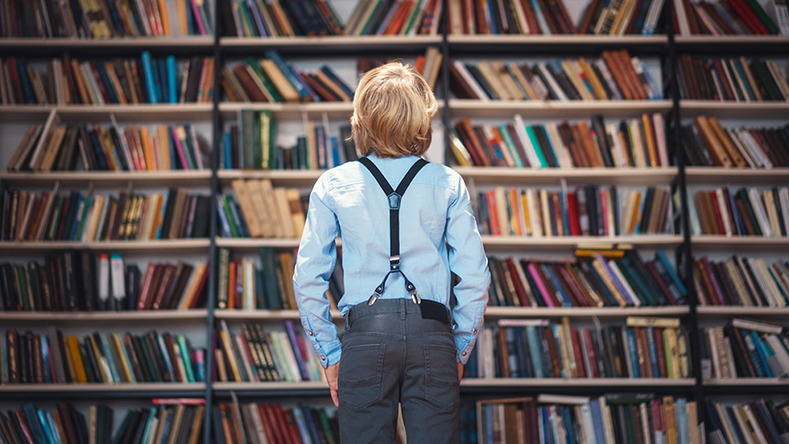 Child looking at book shelves.